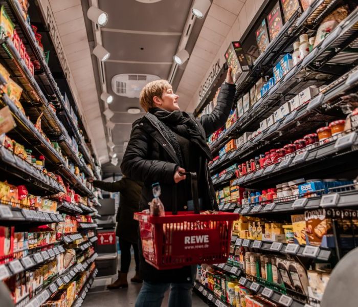 Im REWE-Einkaufs-Bus geht eine Frau einkaufen. (Foto: REWE)